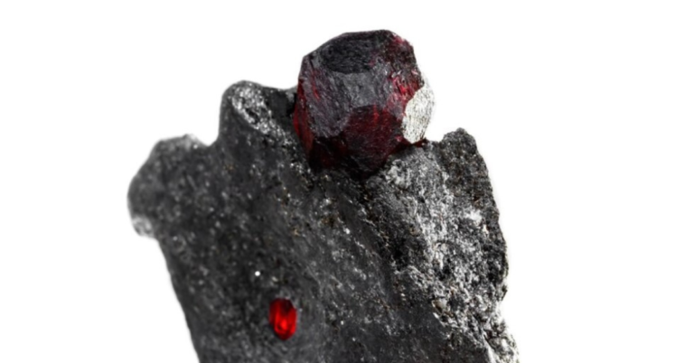 Deep red almandine garnet gemstone in metamorphic rock showcasing natural beauty and clarity