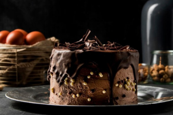 Swiss Chocolate Chalet Cake topped with chocolate curls and fresh berries.